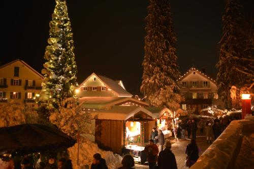 a group of people walking around a christmas market at Hotel Post - regionales großes Frühstücksbuffet - auch GF & LF in Scheidegg