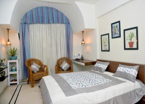 a bedroom with a large bed and two chairs at Paradise Homestay Civil Lines in Nagpur