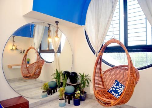 a room with two wicker chairs and mirrors at Paradise Homestay Civil Lines in Nagpur