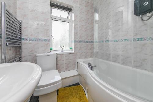 baño blanco con bañera, aseo y lavamanos en The Comfy Resort, Free Private Parking & Wifi, 9 beds en Colchester