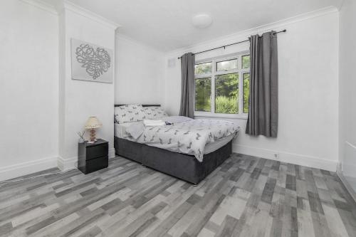 a white bedroom with a bed and a window at The Comfy Resort, Free Private Parking & Wifi, 9 beds in Colchester