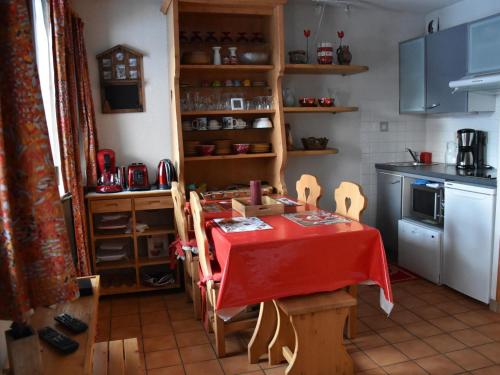 une cuisine avec une table et un chiffon rouge dans l'établissement Appartement cosy et lumineux - 4 pers, balcon sud, départ skis aux pieds, proche centre et pistes - FR-1-464-93, à Pralognan-la-Vanoise