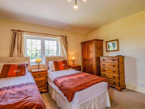 a bedroom with two beds and a dresser and a window at The Orchard in Rye