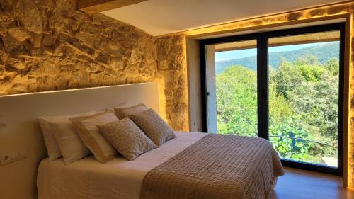 a bedroom with a bed and a large window at Casa Leirón in Parada del Sil