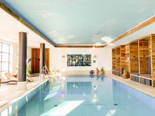 a swimming pool in a house with a ceiling at Yachthotel Chiemsee GmbH in Prien am Chiemsee