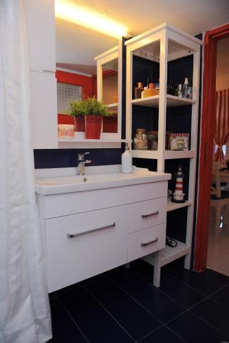 a bathroom with a white sink and a shelf at Dandy Villas Velanidia Sailor's House - Private Maisonette - Sea View in Velanídhia