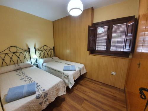 a bedroom with two beds and a window at Preciosa casa en capileira in Capileira
