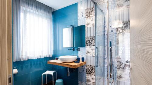a blue bathroom with a sink and a shower at Zaffiro Lavico rooms Etna nature sea in Acireale