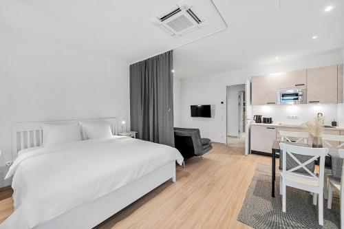 sypialnia z łóżkiem i biurkiem oraz kuchnią w obiekcie VibeStudio 303 - Central - AC - Near Parking w Wiedniu