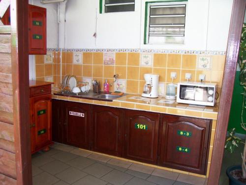 a small kitchen with a sink and a microwave at Hôtel Le Nathania in Saint-Pierre