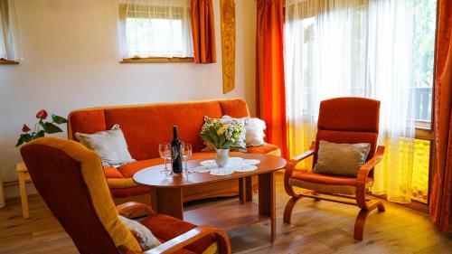 a living room with orange chairs and a table at CHATA U VINCENTA s fínskou saunou a altánkom in Hnilčík