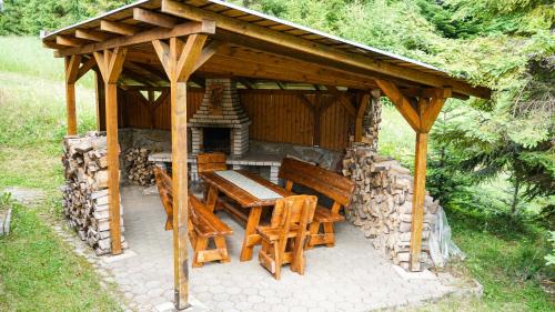 a wooden pavilion with a wooden table and chairs at CHATA U VINCENTA s fínskou saunou a altánkom in Hnilčík