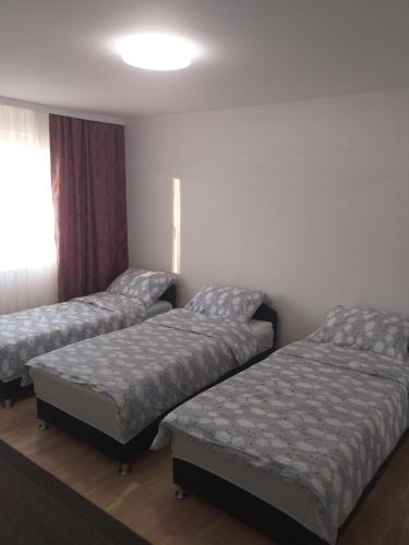 a room with three beds and a window at Apartment Ilidza-SK in Sarajevo