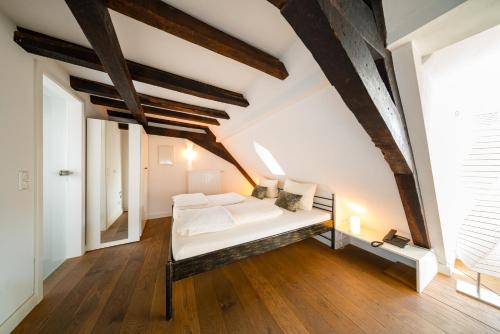 a bedroom with a white bed in the attic at Gästehaus Ratsschänke in Zeltingen-Rachtig