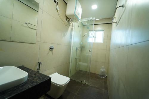 W łazience znajduje się prysznic, toaleta i umywalka. w obiekcie vihangama Home Stay w mieście Chāmundi