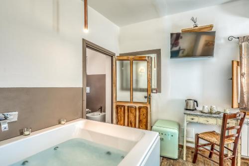 a bathroom with a tub and a table and a chair at Trulli Terra Magica in Putignano