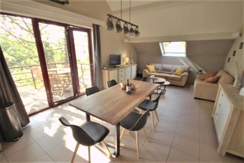 uma cozinha e sala de estar com uma mesa de madeira e cadeiras em stay at durbuy em Durbuy