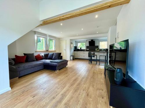 a living room with a couch and a kitchen at Sky Apartment, Sauna, Blick zur Mosel, großer Balkon, Kaffeemaschine, Smart TV in Zell an der Mosel