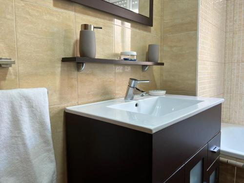 un bagno con un lavandino bianco e uno specchio di Piso familiar con perfecta ubicación a Cordoba