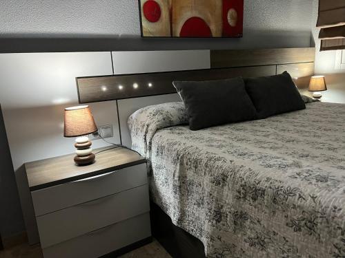 una camera da letto con un letto e una lampada sul comodino di Piso familiar con perfecta ubicación a Cordoba
