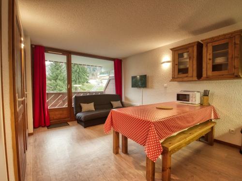 un salon avec une table et un canapé dans l'établissement Appartement cosy 6 pers, cuisine équipée, balcon, casier à skis - Morillon 1100 - FR-1-642-15, à Morillon
