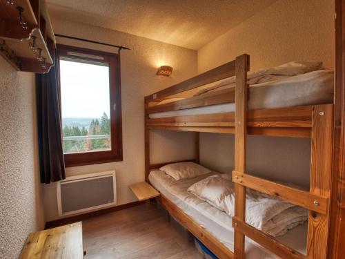 a bedroom with two bunk beds and a window at Appartement Morillon 1100, 3 pièces, 6 personnes - FR-1-642-15 in Morillon