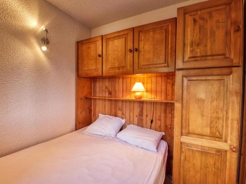 ein kleines Schlafzimmer mit einem Bett und Holzschränken in der Unterkunft Appartement Morillon 1100, 2 pièces, 6 personnes - FR-1-642-32 in Morillon