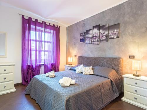 a bedroom with a large bed with purple curtains at Castle Suite - centro storico in Rivoli