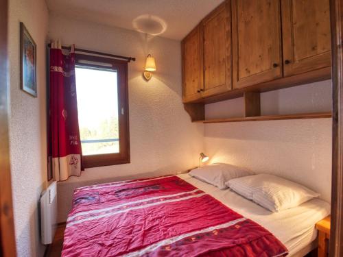 une chambre avec un grand lit avec une couverture rouge dans l'établissement Appartement cosy pour 4, au pied des pistes à Morillon 1100, proche jardin d'enfants - FR-1-642-41, à Morillon
