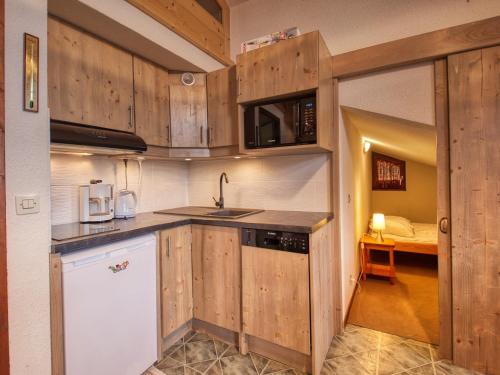 La cuisine est équipée de placards en bois, d'un évier et d'un four micro-ondes. dans l'établissement Confortable Duplex Mezzanine - Pied des Pistes et Balcon - FR-1-642-48, à Morillon