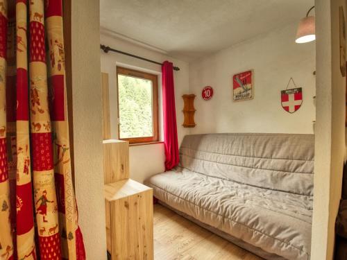 een kleine slaapkamer met een bed en een raam bij Appartement Morillon 1100, 2 pièces, 5 personnes - FR-1-642-45 in Morillon