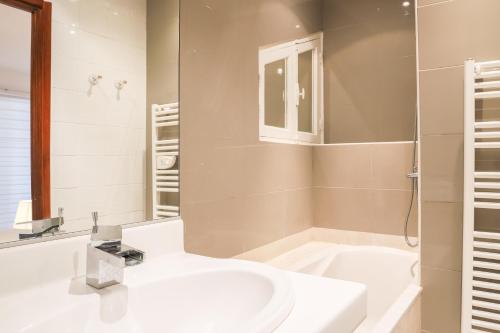 uma casa de banho branca com um lavatório e um chuveiro em ACCI Cannes Marina em Cannes