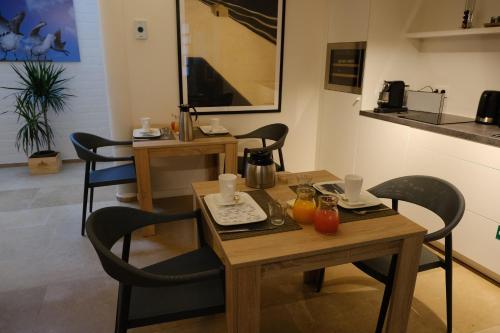 una sala da pranzo con tavolo e sedie in legno di James & Leon a Ostenda