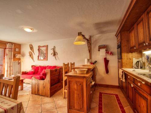 Il comprend une cuisine et un salon avec un canapé rouge. dans l'établissement Bel appartement 3 chambres au pied des pistes à Morillon 1100 avec balcon et wifi - FR-1-642-57, à Morillon