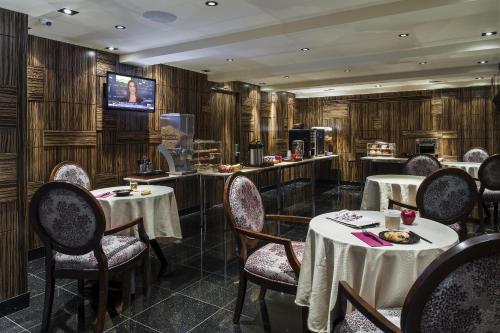 uma sala de jantar com mesas e cadeiras e uma televisão em Opera House Hotel em Bronx