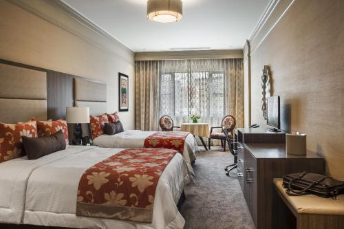 a hotel room with two beds and a television at Opera House Hotel in Bronx