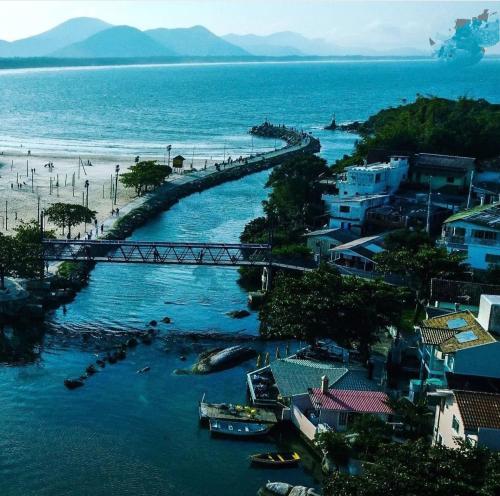 vistas a una playa con un puente sobre el agua en Residencial BeachMar & Mael, en Florianópolis