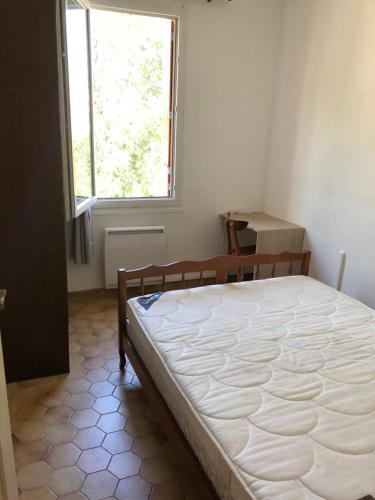 um quarto com uma cama grande num quarto com uma janela em Grande maison de ville avec jardin T7 perpignan em Perpignan