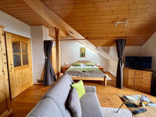1 dormitorio con cama, sofá y TV en Ferienwohnung AlmLust, en Hochrindl