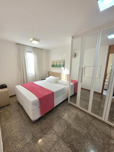 1 dormitorio con 1 cama grande y espejo en Life Resort By Rei dos Flats, en Brasilia