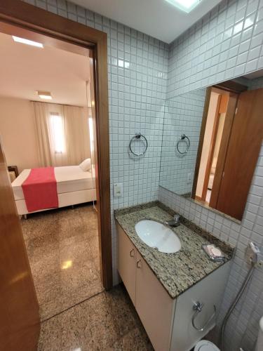 baño con lavabo, espejo y cama en Life Resort By Rei dos Flats, en Brasilia