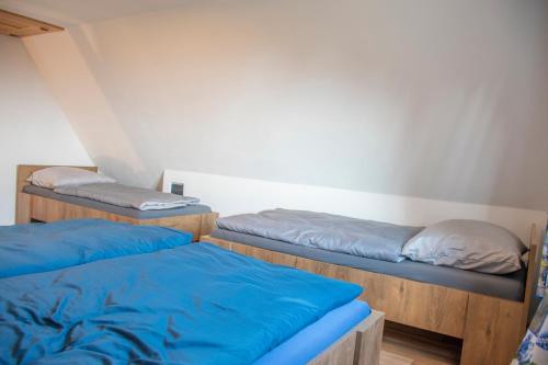 a room with two bunk beds with blue sheets at Chata Na Vyhlídce in Železnice