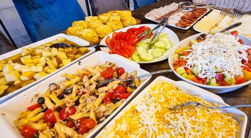 een tafel met dienbladen van verschillende soorten levensmiddelen bij Heritage Hotel Stypia in Crikvenica