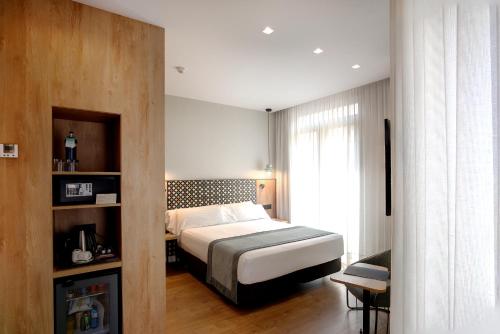 a hotel room with a bed and a window at Catalonia Excelsior in Valencia