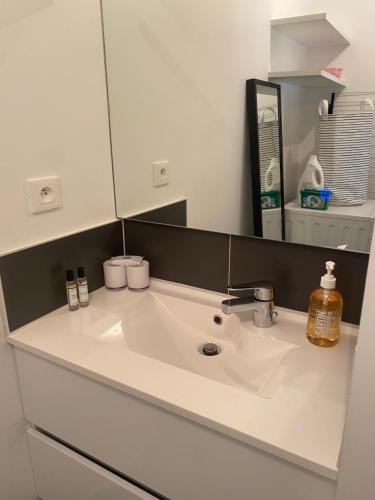 a white sink in a bathroom with a mirror at Petit cocon douillet avec terrasse in La Rochelle