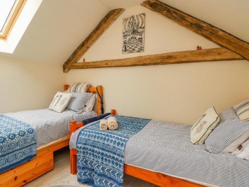 1 dormitorio con 2 camas y techo con vigas. en Buzzards Breg en Builth Wells