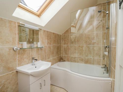 a bathroom with a bath tub and a sink at Buzzards Breg in Builth Wells