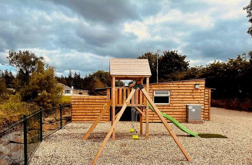 a wooden playset with a house on top of it at Walsh's - Mill Lodges-Cabins in Maghera