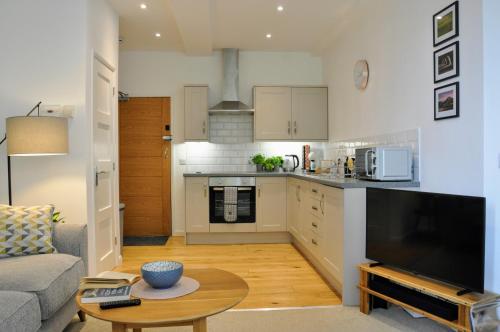 una cucina e un soggiorno con divano e tavolo di Crescent House Apartments a Telford