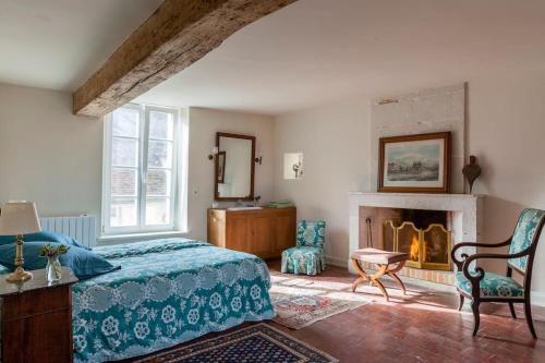 een slaapkamer met een bed en een open haard bij Charming Normandy Country Home in Condeau
